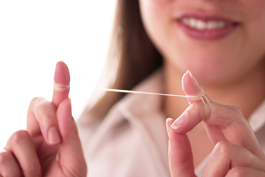 A woman holding oral floss