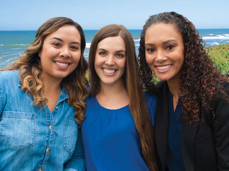 Three lady friends dental patients Bancroft Dental Care smiling by the coast